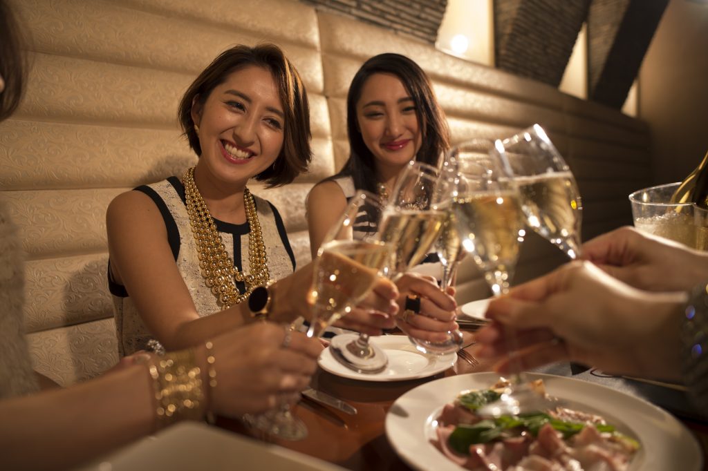 Women are toast with champagne in the restaurant
