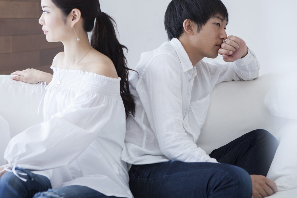 Young couple has turned their backs to each other sitting on the sofa